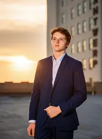 Senior portrait in downtown Mobile, Alabama— waist up in his dress suit looking slight off camera.