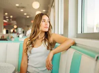 Senior portrait at Sunliner Diner in Gulf Shores, Alabama — sitting in a booth and looking out
the window.