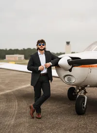 Senior portrait at a small hangar near Mobile International Airport in Mobile, Alabama — posing near airplane