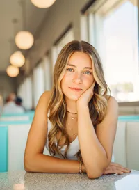 Senior portrait at Sunliner Diner in Gulf Shores, Alabama — close-up in the booth with her elbow
resting on the table.