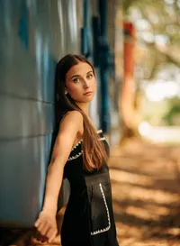 Senior portrait in downtown Foley, Alabama — leaning against a stationary blue train car.