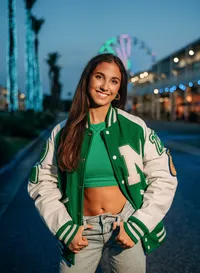 Senior portrait at The Wharf in Orange Beach, Alabama — wearing a Millry letterman jacket with
the Ferris wheel in the background.
