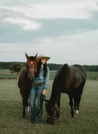Senior portrait at Triple T Farms in Fruitdale, Alabama — standing beside two horses as one
faces the camera and the other grazes.
