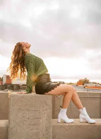 Senior girl flipping her hair on a parking garage rooftop in downtown Mobile, Alabama.