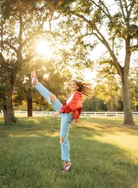 Senior portrait in downtown Magnolia Springs, Alabama — showing her kick moves from the high school dance team.