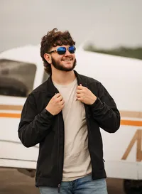 Senior portrait at a small hangar near Mobile International Airport in Mobile, Alabama — posing near airplane