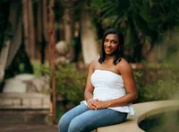 Senior portrait at Bella Sera Gardens in Loxley, Alabama — entering the courtyard beneath an
archway.