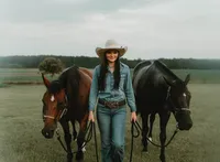 Senior portrait at Triple T Farms in Fruitdale, Alabama — walking toward the camera while
leading two horses.