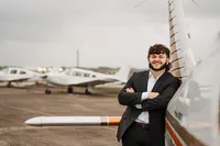 Senior portrait by a small airplane near the Mobile International Airport.
