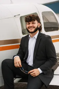 Senior portrait at a small hangar near Mobile International Airport in Mobile, Alabama — posing near airplane