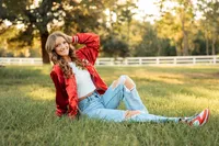 Senior portrait in downtown Magnolia Springs, Alabama — posing in the grass.