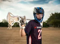 Senior portrait at Battleship Memorial Park in Mobile, Alabama— wearing his lacrosse helmet