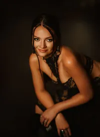 Senior portrait at Triple T Farms in Fruitdale, Alabama — smiling in a black lace dress while
holding a vinyl record.