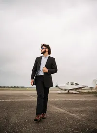 Senior portrait at a small hangar near Mobile International Airport in Mobile, Alabama — posing near airplane