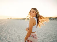 Senior portrait on the beach in Gulf Shores, Alabama — hair flip while walking toward the
camera.