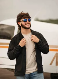 Senior posing in front of an airplane at a small hangar near Mobile Regional Airport in Mobile, Alabama.