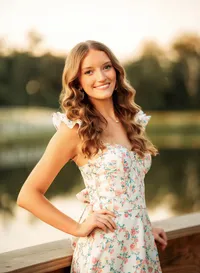 Senior portrait in downtown Magnolia Springs, Alabama — posing with hand on hip near a poind.
