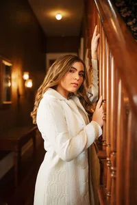 Senior portrait at the Malaga Inn in Mobile, Alabama— closeup holding the rails of the bannister.