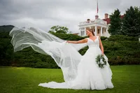 A bride's veil catches the wind on the lawn at The Manor House in Littleton, Colorado.