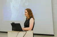 Jill Wright speaking at a conference about sustainable productivity, workload management, and high performance.