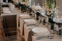 Décoration de table élégante et moderne pour un mariage au Café de l’Horloge, avec fleurs blanches, chandelles et vaisselle raffinée, photographiée par Jeff Gagnon photographe.