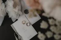Flat lay de détails de mariage incluant les alliances, la papeterie, et les chaussures de la mariée, capturé avec soin et élégance par Jeff Gagnon photographe.