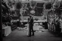 Mariés partageant leur premier baiser sous un lustre suspendu, décor floral abondant et verdure retombante, cérémonie au Richmond, Montréal