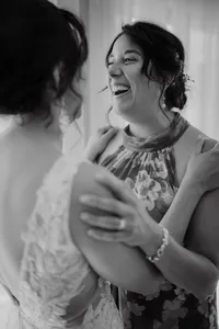 Instant complice et rempli d’émotion entre la mariée et une amie proche pendant les préparatifs du mariage, capturé en noir et blanc par Jeff Gagnon photographe.