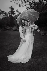 Couple de mariés sous un parapluie transparent lors d’un mariage pluvieux et moody dans les Laurentides, photographié par Jeff Gagnon photographe.