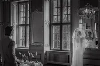 Mariée ajustant son voile près d'une haute fenêtre à petits carreaux, boiseries sculptées et miroir ancien, lumière naturelle et fleurs blanches, préparatifs au Ritz-Carlton, Montréal