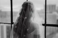 Portrait poétique d’une mariée de dos, voilée et baignée de lumière naturelle au Studio Giovanelli à Montréal, capturé dans un style moody par Jeff Gagnon photographe.