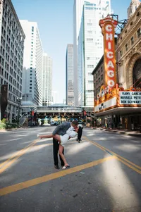 Newlyweds kissing in front of iconic Chicago Theatre marquee sign after City Hall wedding