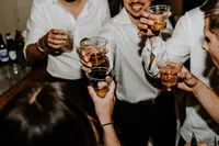 Wedding guests raising their glasses together for a toast during a New England wedding reception.