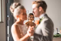 Bride smiling at her groom while dancing at their New England wedding reception, captured by a Maine wedding photographer.