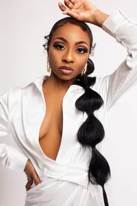 Birthday portrait of woman with natural hair in a silk white dress.