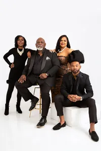 Family in all black formal attire posing for family portrait.