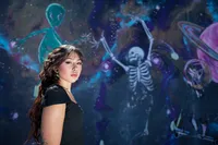 Iowa non-traditional pierced tattoo artist at skate park graffiti wall with dancing skelloton
