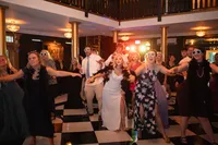 Reception party dancing into the night at Iowa's wedding venue with checkered flooring and fun dj lighting
