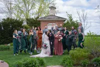 Bridal party portrais bride and groom kissing with wedding party jumping for joy