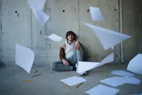 Iowa senior session with black white paper flying in the air with #2 wooden pencils scattered throughout artistic photography