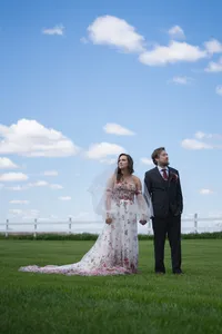 Iowa wedding non-traditional tatted couple with floral dress clear blue sky in grassy field