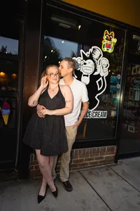 Iowa alternative non-traditional couple supporting local ice cream shop black cat ice cream embracing at storefront