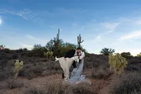 Hispanic couple kiss dip elopement in the dessert of arizona with cactuses