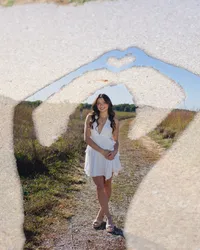 Iowa artistic portrait of senior girl in white dress double exposed on her image with heart hands
