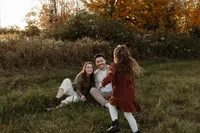 A playful, heartwarming moment of a toddler running through the grass toward her parents.