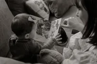Mother reading with her baby in a New England home. Lifestyle family photography capturing tender parent-child moments in natural light.