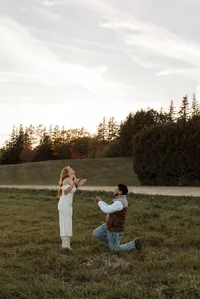 Engaged couple surprise proposal at golden hour during an engagement photography session in Maine.