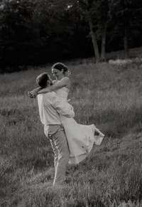 Couple embracing at sunset during a romantic outdoor engagement photography session with golden light and scenic landscape.