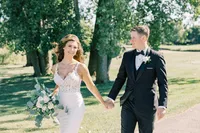 Kelly and Eric outdoors with an organic white floral and greenery bouquet at Eagle Brook Country Club in Geneva, Illinois