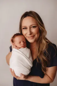 Newborn Photographer in Charleston - Mother embraces her infant during Newborn Portrait Session in Charleston, SC.